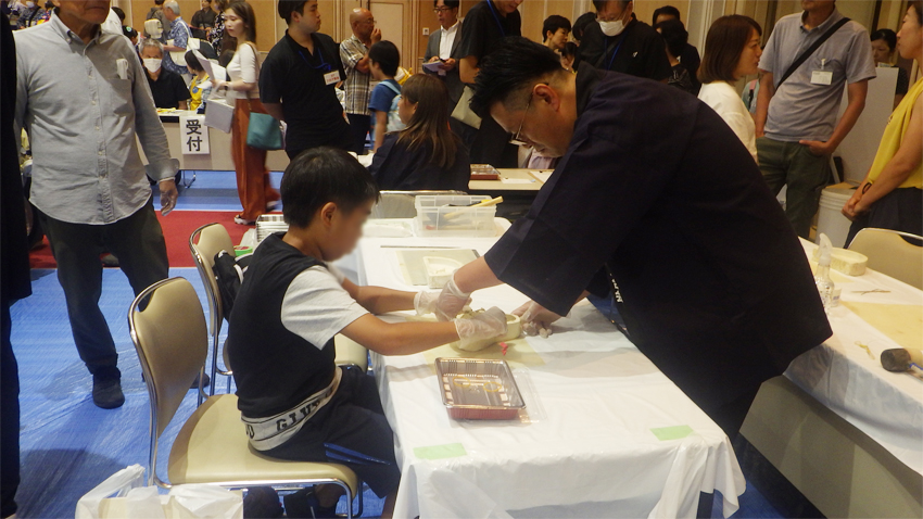 先生が粘土型抜きを指導中